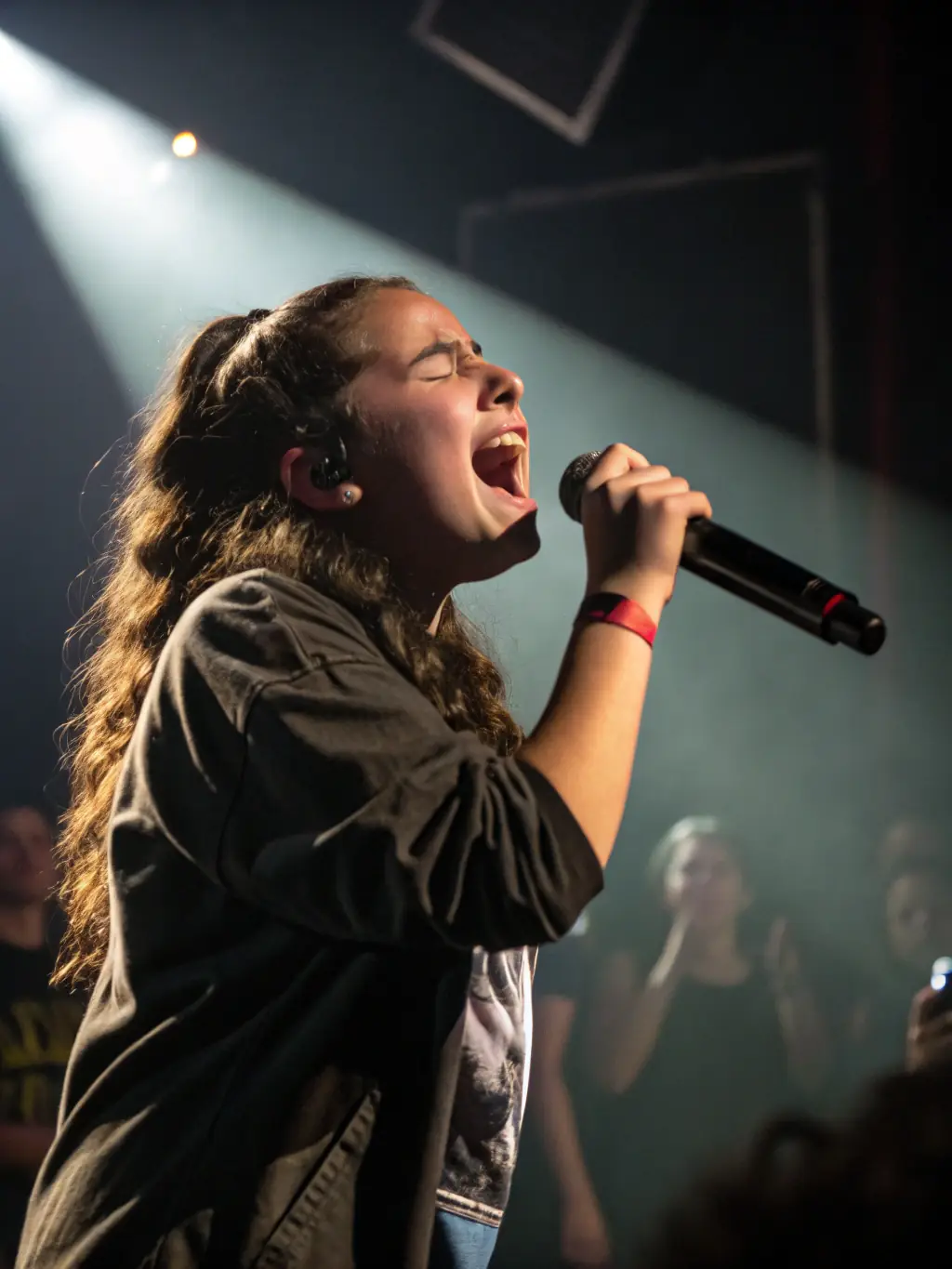 A vibrant photograph capturing a live music performance at a Ca Sonne Terrible event, showcasing a young artist on stage with enthusiastic audience members in the background.